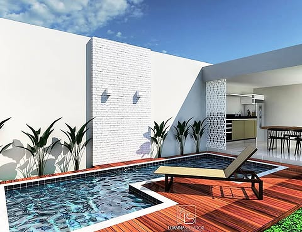 Área de lazer — Piscina com deck de madeira, parede em tijolinho e paisagismo tropical.